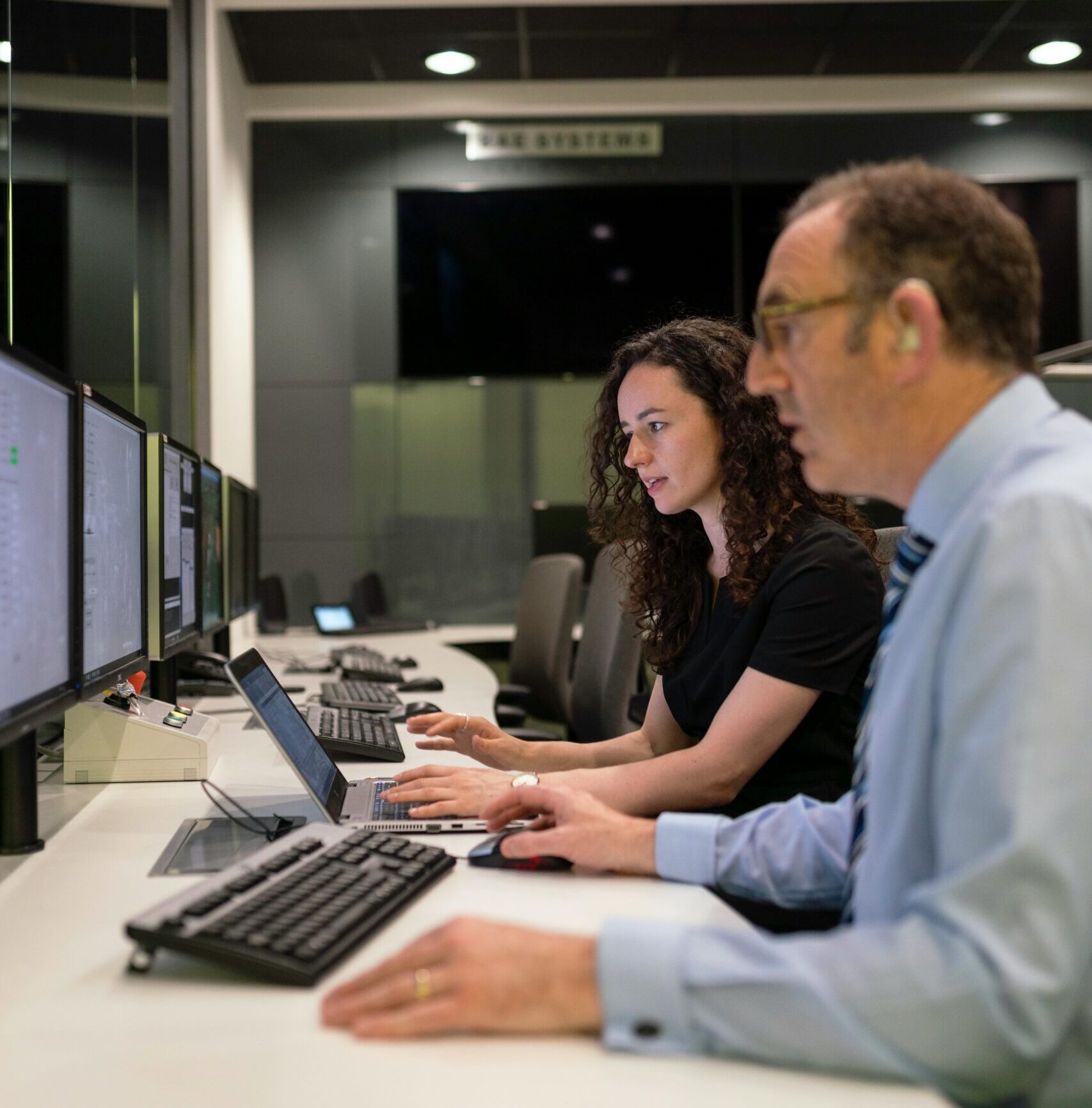 Engineers working together in a modern control room focused on simulation and testing.